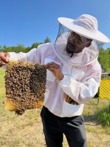 man holding a honeycomb from bee house